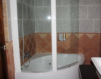 Foto de ducha y bañera con hidromasaje con puertas de vidrio ubicados en baño privado de este hotel