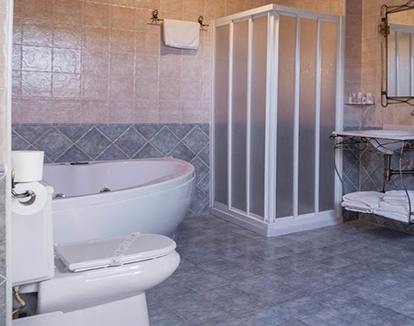 Foto de baño privado con ducha y bañera de hidromasaje de color blanco situado en este lindo hotel