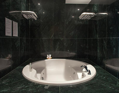 Foto de bañera con hidromasaje de estilo elegante color blanco ocn negro situado en este lujoso hotel