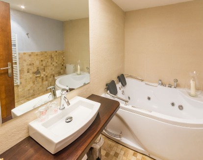 Una bañera de hidromasaje amplia para 2 personas dentro de un baño muy bien ambiantado y decorado para darle un toque de serenidad en el Hotel Villa de Cretas