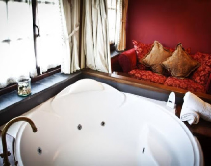 habitación doble superior con paredes rojas y una bañera de hidromasaje redonda en un hotel encantador en cacabelos