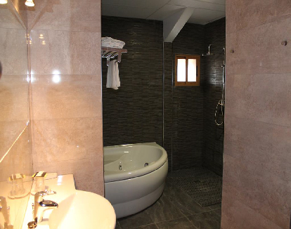 baño de suite con una bañera de hidromasaje redonda en un hotel en Malpartida de Cáceres