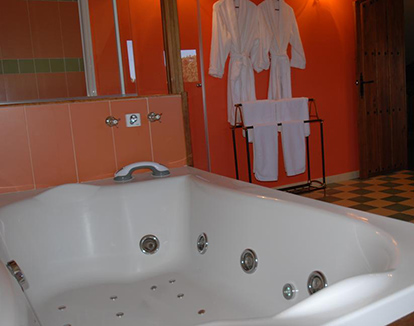Foto de bañera con hidromasaje en forma rectangular de color blanco ubicada en baño privado de este hotel