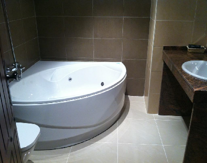 baño de suite con paredes y pisos de ceramica y una bañera de hidromasaje blanca en un hotel en Cañamero, Cáceres