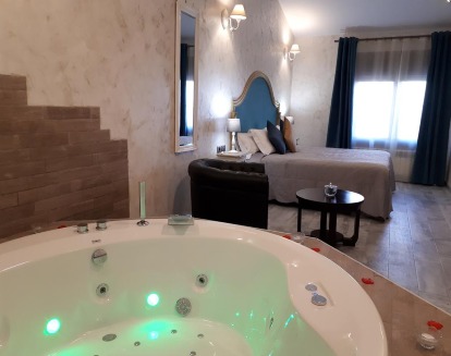 Una bañera de hidromasaje dentro de la habitación a un lado de la cama le da ese toque de romanticismo que las parejas pueden disfrutar en Sierra Palomera 2