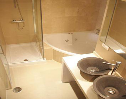 Foto de baño privado con ducha y bañera de forma circular de este hotel