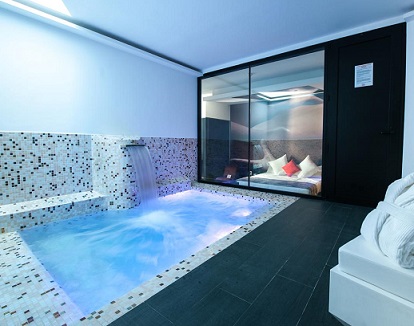 Foto de una de las habitaciones con piscina privada frente a la cama totalmente cubierta y discreta para disfrutar en pareja como quieras.