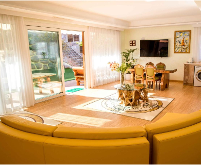 Foto de Villa Eco Geo Sol en donde se ve el área de la sala de estar, comedor y puerta que dá hacia el jardín y la piscina.