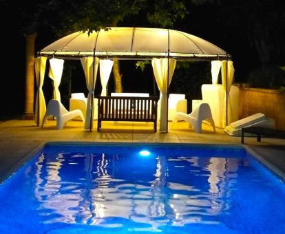 Foto nocturna del área de la piscina en Villa Masia CM