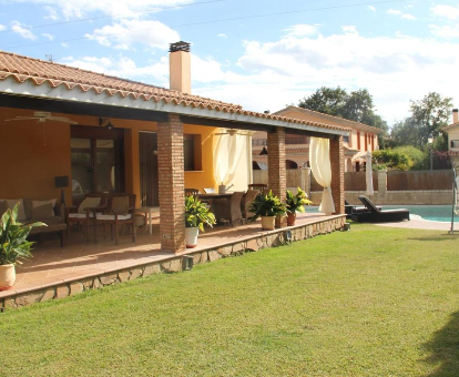Foto externa de Villa sierra de Gata donde se observa su terraza y a lo lejos parte de la piscina