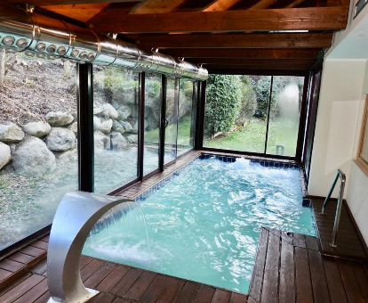 Foto de la piscina cubierta climatizada con cascada de agua