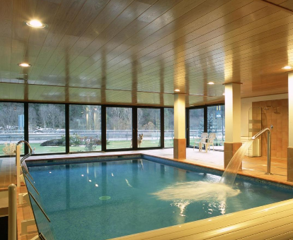 Foto de la piscina cubierta climatizada con chorros de agua y vistas al exterior