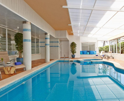 Foto de la piscina cubierta climatizada con tumbonas