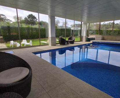 Foto de la piscina cubierta climatizada con vistas al jardin