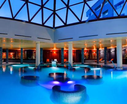 Piscina climatizada del spa del hotel Meliá Sol y Nieve donde se puede ver las luces de la piscina y los grifos para chorros de agua en los laterales.