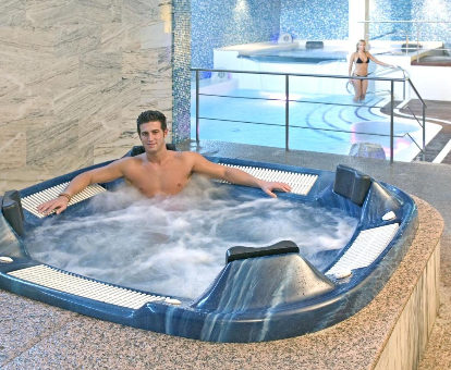 Foto de la bañera de hidromasaje y la piscina cubierta climatizada del spa