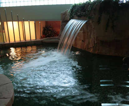 Foto de la piscina interior con cascada del spa
